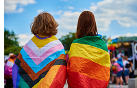 two people with rainbow flags around shoulders