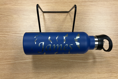 blue metal water bottle on a stand with silver name and bats 