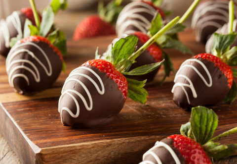 Strawberries dipped in chocolate with white chocolate swirls on top.