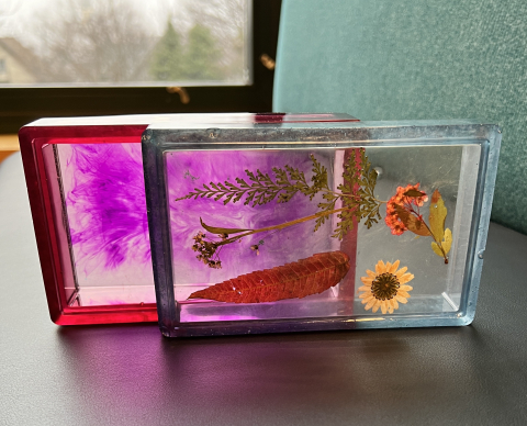 A multicolor resin box with flowers embedded inside. 