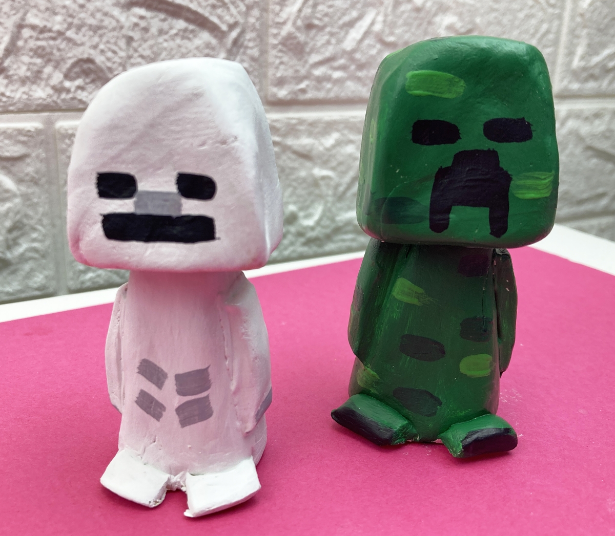 Two clay minecraft creeper bobbleheads