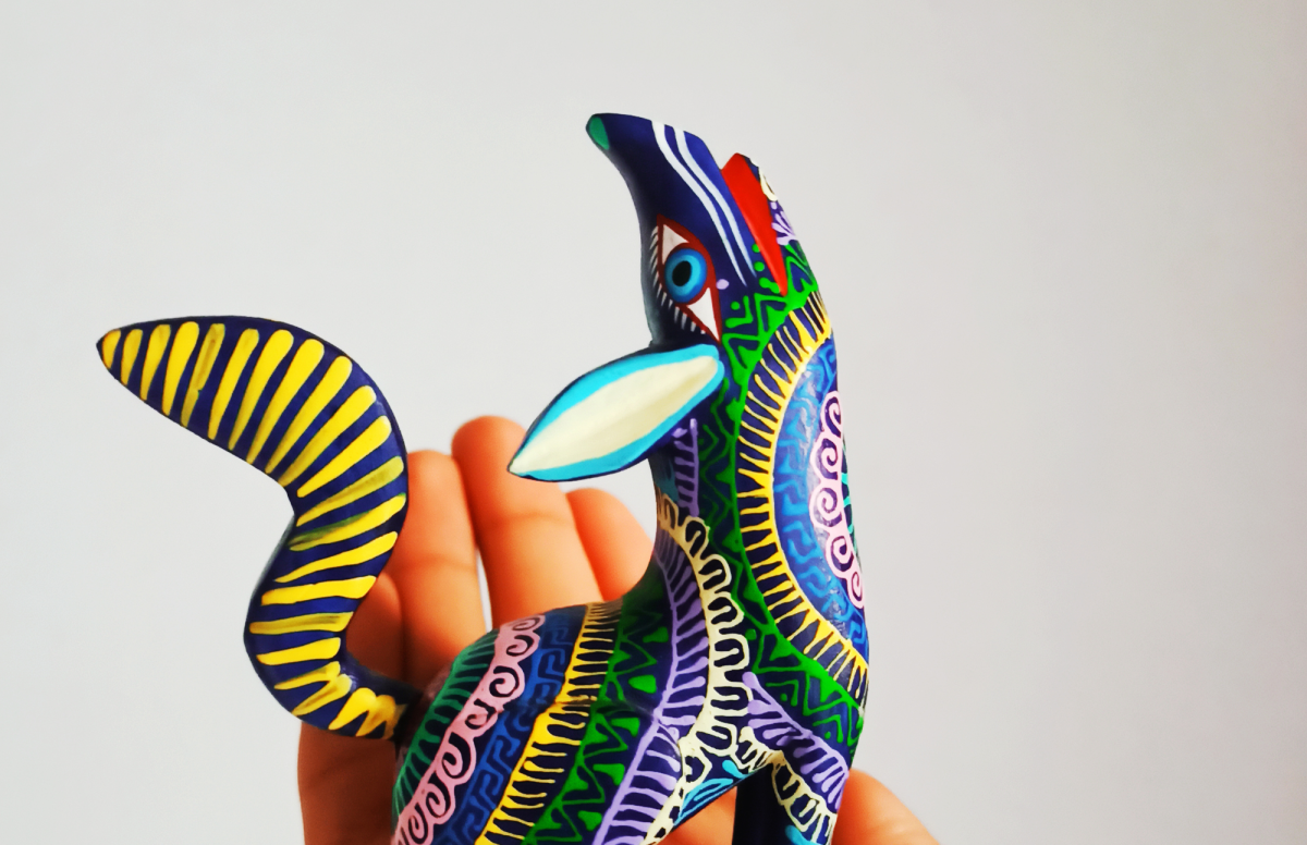 Brightly painted coyote sits in a person's hand